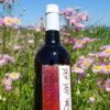 花畑を背景にした赤ワインボトル